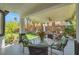Beautiful covered patio with an outdoor dining area and view of the landscaped backyard at 5785 Farmhouse Ct, Las Vegas, NV 89141