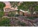 Charming home with a beautifully landscaped front yard featuring brickwork, lush greenery, and mature shade trees at 639 I Ave, Boulder City, NV 89005
