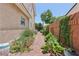Landscaped side yard with brick pathway and vibrant green plants at 639 I Ave, Boulder City, NV 89005