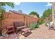 Brick patio and walkway in the yard with a bench seating along a brick wall and lush landscaping at 639 I Ave, Boulder City, NV 89005