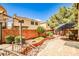 Backyard with paver patio, metal bridge feature, landscaped garden beds, and mature shade trees at 6409 Shawnee Springs Ct, Las Vegas, NV 89139