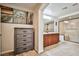 Bathroom with stone tile, wood cabinets, vanity, and a large glass-enclosed shower at 6409 Shawnee Springs Ct, Las Vegas, NV 89139