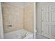 Bathroom featuring a tiled shower, a shower head, a bathtub, a door, and a rug on the floor at 6409 Shawnee Springs Ct, Las Vegas, NV 89139