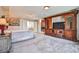 Large carpeted bedroom with a huge wooden entertainment center and king-sized bed at 6409 Shawnee Springs Ct, Las Vegas, NV 89139
