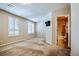 Spacious bedroom featuring two windows, neutral carpeting, and an adjacent bathroom at 6409 Shawnee Springs Ct, Las Vegas, NV 89139