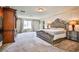 Spacious carpeted bedroom with a large bed and wooden furniture, plus a ceiling fan at 6409 Shawnee Springs Ct, Las Vegas, NV 89139