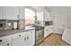 Bright kitchen featuring white cabinets, granite counters, tile backsplash, stainless steel appliances and tile floors at 6409 Shawnee Springs Ct, Las Vegas, NV 89139