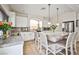 Open kitchen featuring a large island with bar seating, white cabinets, stainless appliances, and decorative backsplash at 6409 Shawnee Springs Ct, Las Vegas, NV 89139