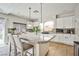 Open kitchen featuring a large island with bar seating, white cabinets, stainless appliances, and decorative backsplash at 6409 Shawnee Springs Ct, Las Vegas, NV 89139