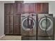 Laundry room with dark wood cabinets providing ample storage and side-by-side high efficiency washer and dryer at 6409 Shawnee Springs Ct, Las Vegas, NV 89139