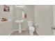 Bathroom with pedestal sink, wall mirror, toilet, and neutral paint at 6626 Seahorse Reef St, Las Vegas, NV 89149