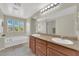 Bathroom with double sinks, stone countertop, and large soaking tub at 6626 Seahorse Reef St, Las Vegas, NV 89149