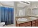 Bathroom featuring double sinks, granite countertops, and a shower with a blue curtain at 6626 Seahorse Reef St, Las Vegas, NV 89149