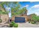 Two-story home with a well-manicured front yard, blue garage door, and charming desert landscaping at 6626 Seahorse Reef St, Las Vegas, NV 89149