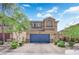 Inviting two-story home with a blue garage door, stone accents, and a well-maintained front yard at 6626 Seahorse Reef St, Las Vegas, NV 89149