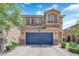 Charming two-story home showcasing a blue garage door, complemented by stone accents and manicured landscaping at 6626 Seahorse Reef St, Las Vegas, NV 89149