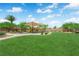 A community playground is surrounded by lush green grass and mature trees, creating a fun and safe environment at 6626 Seahorse Reef St, Las Vegas, NV 89149