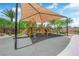A playground with a sunshade, climbing ropes, and a slide promotes outdoor activity in a safe environment at 6626 Seahorse Reef St, Las Vegas, NV 89149