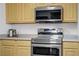 Close-up of stainless steel oven and microwave with light cabinetry and countertops at 6955 N Durango Dr # 3089, Las Vegas, NV 89149