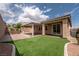 Beautiful backyard featuring artificial turf, covered patio, and a relaxing hot tub at 7525 Campbell Ranch Ave, Las Vegas, NV 89179