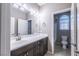 Bathroom features a long countertop, dark wood cabinets, and a door to the shower and toilet at 7525 Campbell Ranch Ave, Las Vegas, NV 89179