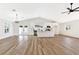 Bright living room with wood-look floors, white walls, a modern chandelier, and an open kitchen with stainless appliances at 811 Spyglass Ln, Las Vegas, NV 89107
