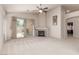 Cozy living room featuring a stone fireplace, neutral decor, and a sliding door to the outdoor pool area at 8266 Lincoln Valley St, Las Vegas, NV 89123
