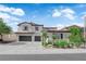 Inviting two-story home featuring a spacious driveway and desert landscaping, creating great curb appeal at 8268 Nelson Ridge Ln, Las Vegas, NV 89178