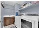 Practical laundry room equipped with washer, dryer, utility sink, and ample shelving at 8268 Nelson Ridge Ln, Las Vegas, NV 89178