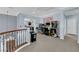 View of the loft area with arcade games, hardwood railing, and view into the living room at 8268 Nelson Ridge Ln, Las Vegas, NV 89178