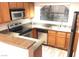 Well-lit kitchen with granite counters, stainless steel appliances, and wood cabinetry at 8455 W Sahara Ave # 213, Las Vegas, NV 89117