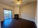 Spacious living room featuring a fireplace, sliding glass door to the patio and dark wood floors at 8455 W Sahara Ave # 213, Las Vegas, NV 89117