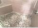 Custom shower featuring a river rock floor and neutral-tone wall tiles at 8455 W Sahara Ave # 213, Las Vegas, NV 89117