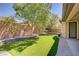 Landscaped backyard with artificial turf, mature trees, and stone accents, offering a serene outdoor retreat at 8544 Garden Valley Ct, Las Vegas, NV 89178
