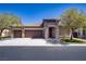 Charming home exterior with a stone facade, three-car garage, and well-manicured lawn, showcasing curb appeal at 8544 Garden Valley Ct, Las Vegas, NV 89178