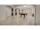 Open-concept game room and bar area featuring light wood-look tile flooring and arched doorways at 8544 Garden Valley Ct, Las Vegas, NV 89178