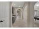 Elegant hallway featuring arched doorways, light wood-look tile flooring, and a built-in bar area at 8544 Garden Valley Ct, Las Vegas, NV 89178