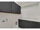 Laundry room with dark gray cabinets and granite counters at 8544 Garden Valley Ct, Las Vegas, NV 89178