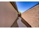 Narrow side yard with a stone pathway and gravel landscaping, providing access to the backyard and additional space at 8544 Garden Valley Ct, Las Vegas, NV 89178