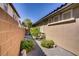 Narrow side yard with gravel landscaping, a stone pathway, and mature shrubs, offering privacy and functionality at 8544 Garden Valley Ct, Las Vegas, NV 89178