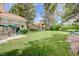 Expansive backyard featuring a lush lawn, mature trees, and outdoor dining area for serene relaxation at 8591 Heather Downs Dr, Las Vegas, NV 89113