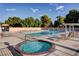 Inviting community pool with a hot tub, surrounded by lounge chairs and mature trees, creating a relaxing atmosphere at 8591 Heather Downs Dr, Las Vegas, NV 89113