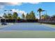 A blue and green tennis court features a net and surrounding black fence at 8591 Heather Downs Dr, Las Vegas, NV 89113