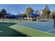 Community tennis courts with blue coverings and trees in the background at 8591 Heather Downs Dr, Las Vegas, NV 89113