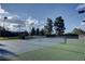 Well-maintained tennis courts ready for a match, surrounded by lush greenery and under a partly cloudy sky at 8591 Heather Downs Dr, Las Vegas, NV 89113