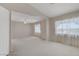Bright and spacious living room featuring neutral carpet and large windows at 8913 Loggers Mill Ave, Las Vegas, NV 89143