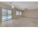 Open living room with sliding glass doors to a pool and neutral tile flooring at 8913 Loggers Mill Ave, Las Vegas, NV 89143