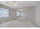 Large open living room with neutral carpet, ceiling fan, and windows at 8913 Loggers Mill Ave, Las Vegas, NV 89143
