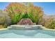 Close up view of the pool waterfall feature surrounded by lush greenery at 8913 Loggers Mill Ave, Las Vegas, NV 89143