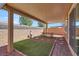 Covered patio with outdoor seating and artificial grass at 9198 Harbin Ave, Las Vegas, NV 89148
